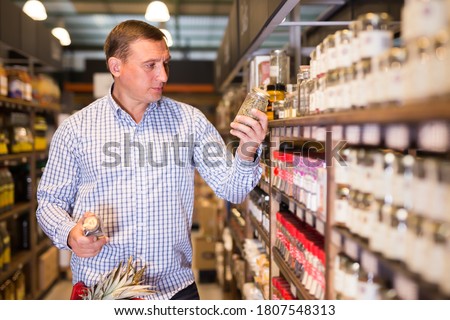 Portrait of ordinary man buying spices in supermarket