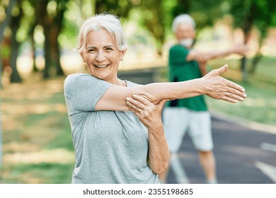 Portrait os a happy beautiful elderly senior mature woman exercising and stretching outdoors