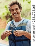 Portrait, outdoor and man with life jacket, smile and nature with safety, getaway trip and vacation. Face, person and guy with adventure, joyful and journey with protection, wellness and recreation