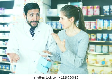 Portrait Of Outraged Woman Customer With Medicines In Pharmacy