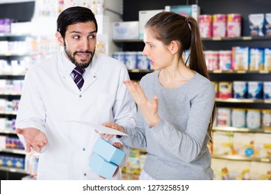 Portrait Of Outraged Woman Customer With Medicines In Pharmacy