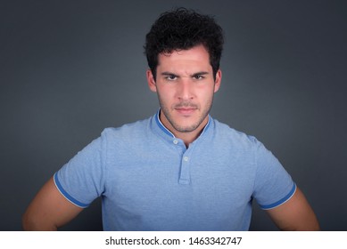 Portrait of outraged young man with oval face, wearing blue T-shirt frowning his eyebrows being displeased with something. Scowling pretty female isolated over grey. - Shutterstock ID 1463342747
