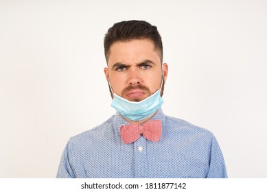 Portrait of outraged young man with oval face, blue eyes wearing medical mask frowning his eyebrows being displeased with something. Scowling pretty female isolated over grey. - Shutterstock ID 1811877142