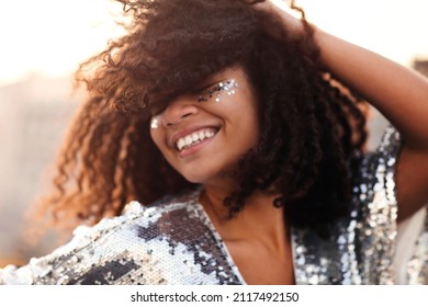Portrait von überglücklicher glamour afrikanischer Frau mit glatter im Gesicht in silbernem Sequin-Kleid, die sich auf einer Far oder Veranstaltung im Freien, gemischte Rennen weibin festlicher Kleidung mit geschlossenen Augen glücklich fühlen