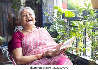  portrait of  overjoyed Indian Senior woman sitting in balcony and reading book - Shutterstock ID 2222599199