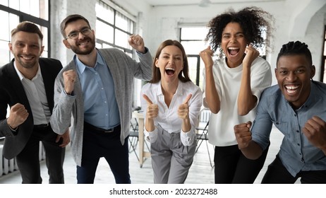 Portrait of overjoyed young diverse employees workers show thumb up recommend good quality company service. Smiling multiethnic colleagues celebrate shared business success or victory in office. - Shutterstock ID 2023272488