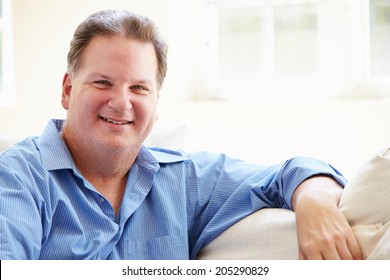 Portrait Of Overweight Man Sitting On Sofa