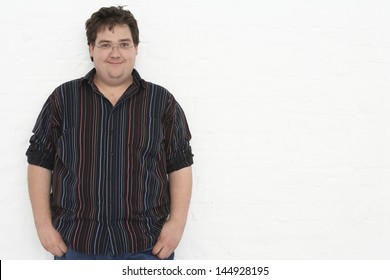 Portrait Of An Overweight Young Man Standing Against White Background