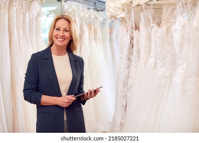 Portrait Of Owner Of Bridal Wedding Dress Shop With Digital Tablet