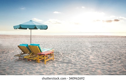 A portrait of a pair of beach chair with umbrella in a seashore
