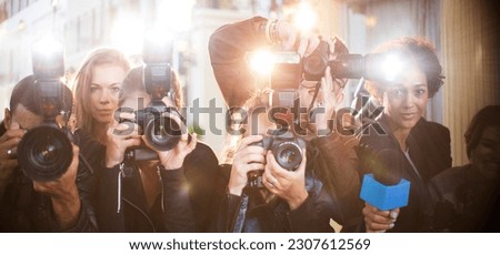 Portrait of paparazzi in a row with cameras and microphone