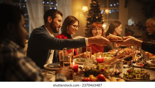 Portrait with Parents, Children and Friends Enjoying Christmas Dinner Together in a Cozy Home in the Evening. Relatives Sharing Meals, Singing Traditional Festive Songs and Setting Off Fireworks