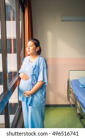 Portrait of patient pregnant asian woman standing smiling and happy in the hospital. Copy space