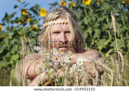 portrait of peasant in a field of sunflowers, get tired from work in summer day