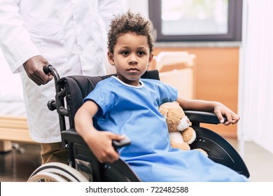 portrait of pensive african american boy in wheelchair looking away in hospital - Powered by Shutterstock