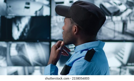 Portrait Of Pensive African-American Guard Looking At Multiple Screens Showing Surveillance Camera Footage. 