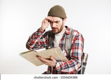 Portrait of a pensive bearded man tourist in plaid shirt carrying backpack and reading a map isolated over white background - Powered by Shutterstock