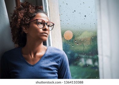 Portrait Of Pensive Black Woman Standing Beside Window