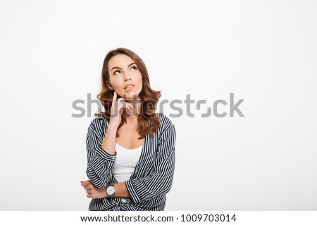 Portrait of a pensive casual girl looking away at copy space isolated over white background