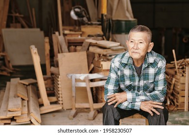 Portrait Of Pensive Experienced Senior Carpenter In Plaid Shirt Resting After Fishing Work On Big Project