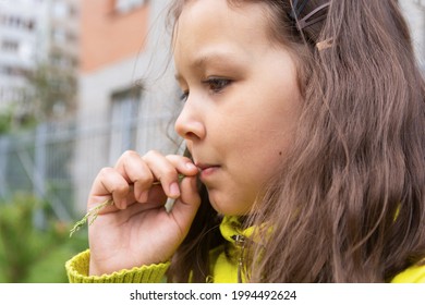 Portrait Of A Pensive Girl 9 Years Old In Profile. Close-up, Outside.