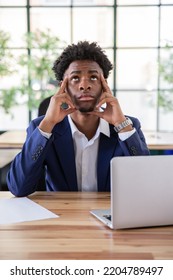 Portrait Of Pensive Male Office Worker. Serious Businessman At Desk Looking Up, Touching Temples. Business Problem, Office Work Concept.