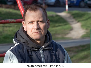 Portrait Of A Pensive Middle-aged Man, 60 Years Old, With Wrinkles, Sad Eyes, Against The Background Of The Street.