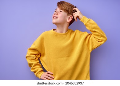 Portrait Of Pensive Teen Boy Isolated On Purple Background. Thoughtful Teenager Holding Hand On Head, Looking Up. Beautiful Caucasian Funny Child In Yellow Shirt Is Thinking, In Contemplation