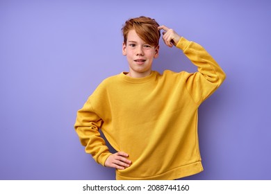 Portrait of pensive teen boy isolated on purple background. Thoughtful teenager holding hand on head, looking at camera. Beautiful caucasian funny child in shirt is thinking, in contemplation - Powered by Shutterstock