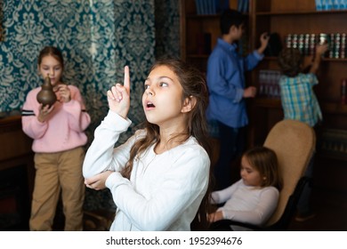 Portrait Of Pensive Tween Girl Solving Riddles In Quest Room, Pointing With Her Forefinger. Concept Of Found Solution