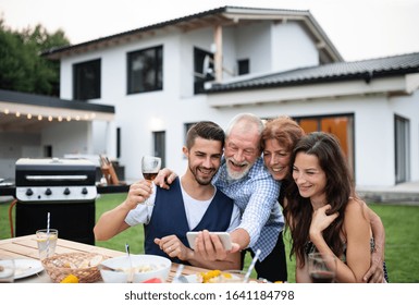 Portrait of people outdoors on family garden barbecue, taking selfie. - Powered by Shutterstock