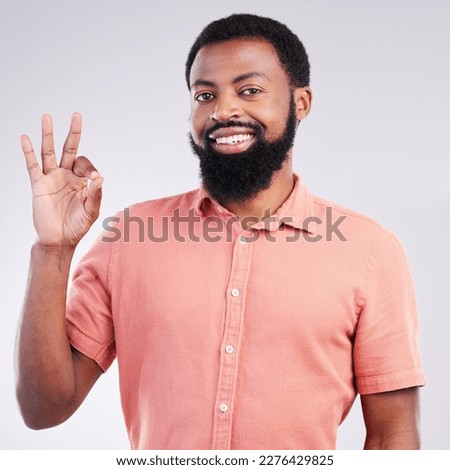 Portrait, perfect and hand gesture with a black man in studio on a gray background to say magnifique. Emoji, communication and okay with a happy or handsome young male speaking in sign language