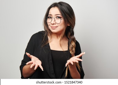 Portrait Of Perplexed Asian Kazakh Girl With A Dazed Face Expression Spreads  Hands, Asking What? Why? OMG, WTF, Human Emotions Concept