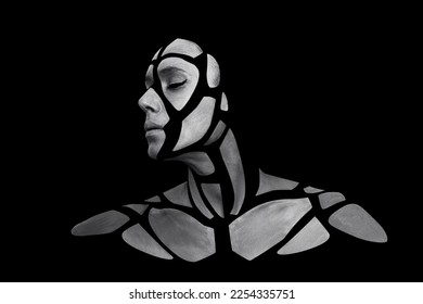 Portrait of person with art creative grey makeup posing in the studio. Shape of gray polygons on beautiful face, shoulders, neck. Pieces of face isolated on dark background. - Shutterstock ID 2254335751