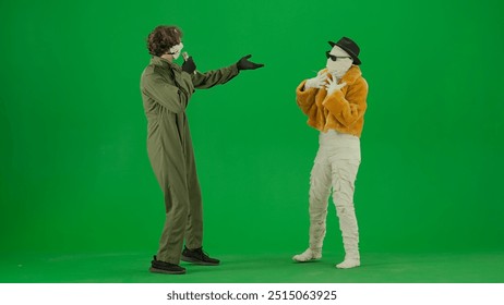 Portrait of person in a mummy bandage on chroma key green screen background. Maniac singing in karaoke microphone mummy dancing with him. - Powered by Shutterstock