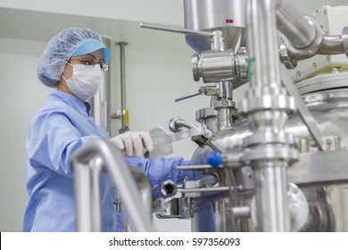 Portrait of Pharmaceutical Worker. Preparing Machine for Work in Pharmaceutical Factory. Female Worker Wearing Protective Clothing in Pharmaceutical Plant. Biomedical and Pharmaceutical Research.