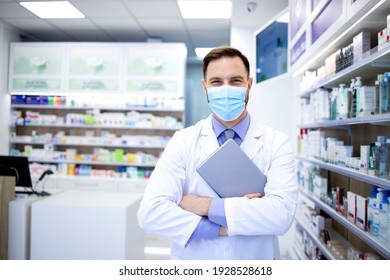 Portrait Of Pharmacist In Protection Mask Holding Tablet Computer And Standing In Pharmacy Shop.