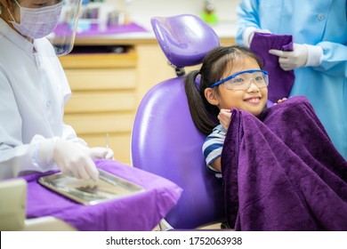 Portrait Photo Of Asian Girl And Dentist Wearing Face Mask And Face Shield Checking Up Teeth Healthy In Dental's Office. Dental Care, Medical Care, Dental Clinic, New Normal Concepts