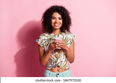 Portrait photo of black skinned pretty woman keeping mug with hot drink smiling isolated on pastel pink color background - Powered by Shutterstock