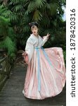 Portrait photo of gentle and beautiful girl in ancient pink Hanfu in ancient garden.