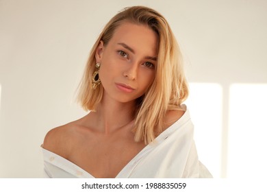 Portrait Photo Of A Gentle Woman In A White Shirt. Photo Of A Blonde In The Sun. A Girl With Bright Makeup, A Lot Of Sparkles On Her Face. Fashion Photography. 
Beauty Shooting
