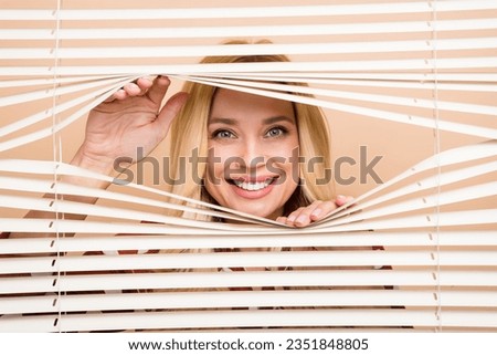 Portrait photo of peering funny woman jalousie office have fun playing hiding looking you peek isolated over beige color background
