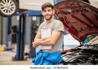 Portrait Photo Of Professional Look Caucasian Vehicle Service Technician Standing Indoor Of Car Repair Shop And Holding Car Inspect Check List.