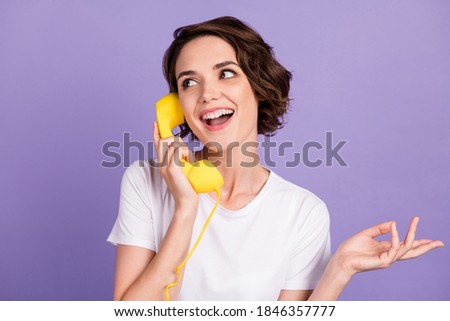 Portrait photo of sociable smiling girl keeping retro telephone yellow handset talking isolated on vivid purple color background Stock fotó © 