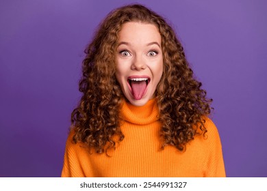 Portrait photo of wavy red hair young funky woman in orange stylish sweater stick tongue out isolated on violet color background