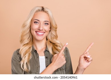 Portrait photo woman blonde hair showing copyspace fingers smiling isolated pastel beige color background - Shutterstock ID 2054140961