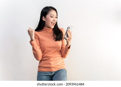 Portrait Photo Of Young Beautiful Asian Woman Feeling Happy Or Surprise Shock And Looking At Smart Phone On White Background Can Use For Advertising Or Product Presenting Concept.