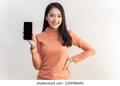 Portrait Photo Of Young Beautiful Asian Woman Feeling Happy Or Surprise Shock And Holding Smart Phone With Black Empty Screen On White Background Can Use For Advertising Or Product Presenting Concept.