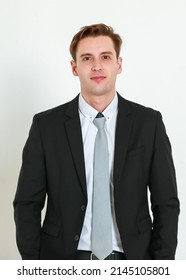 Portrait photo of young businessman in black suit studio shot isolated on white background looking straight at camera with confidence and positvie smile on happy face. Concept for modern man.