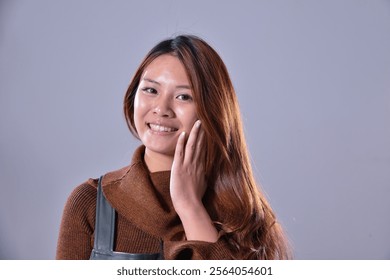 portrait photo of young girl standing wearing sweater  posing in studio